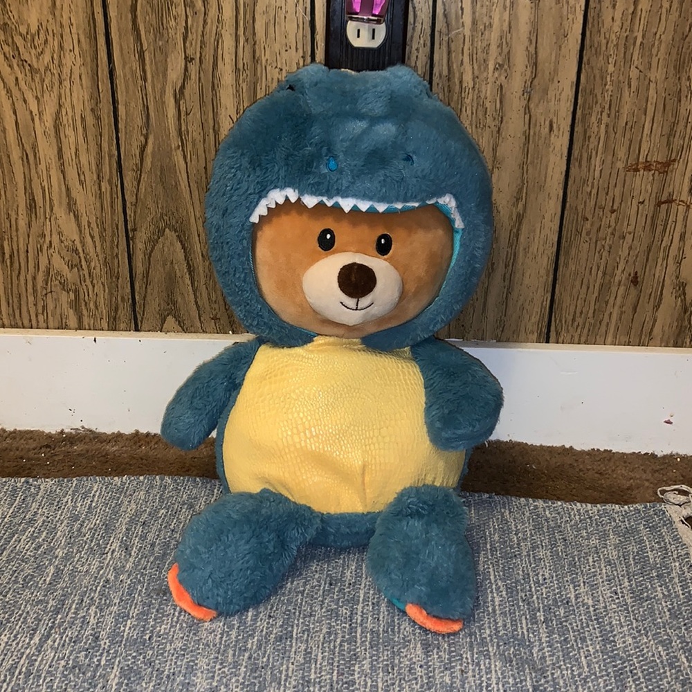 Stuffed bear in dino onesie
